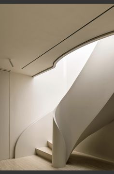 a curved white staircase in a modern building