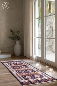 an area rug is on the floor in front of a large window with glass doors