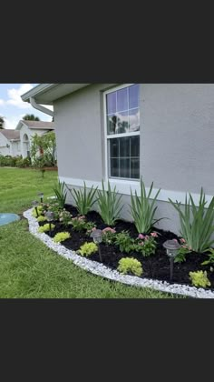 a flower bed in front of a house