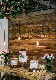 a table with cakes and flowers on it in front of a sign that says glamboo