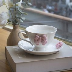 a cup and saucer sitting on top of a book