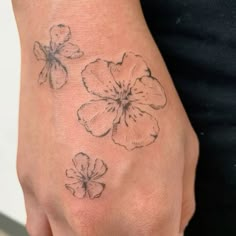 a woman's hand with three flowers on it