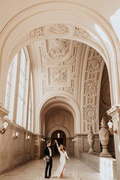 a bride and groom standing in an ornate building