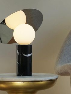 a lamp that is sitting on top of a table next to a chair and mirror