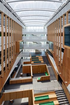 the interior of a large building with wooden benches and green carpeted flooring on both sides