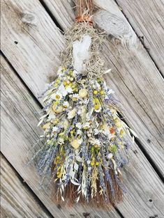 a bunch of dried flowers hanging on a wooden wall