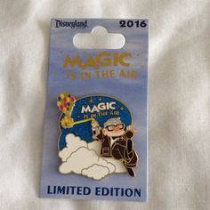 a pin with the words magic is in the air and a cartoon character on it