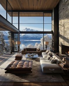 a living room filled with furniture next to a large window covered in snow capped mountains