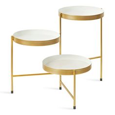 two white and gold side tables with one on each side, the other half empty