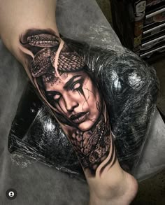 a woman with a snake tattoo on her leg