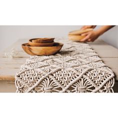 the table runner is crocheted with white yarn and has two bowls on it