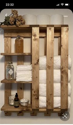 a wooden shelf filled with lots of white towels and toilet paper on top of it