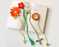 an open book with crocheted flowers on it