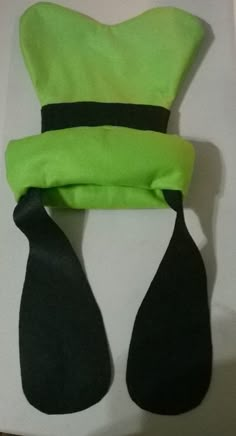 a green hat and two black ties on top of a white box with the lid open