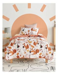 a bed with an orange and white bedspread on it in front of a wall