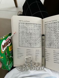 a person holding an open book with crosswords on it and a chain attached to the book