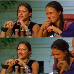 two women sitting at a table and one is laughing while the other holds her hand over her mouth