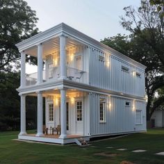 a large white house sitting on top of a lush green field