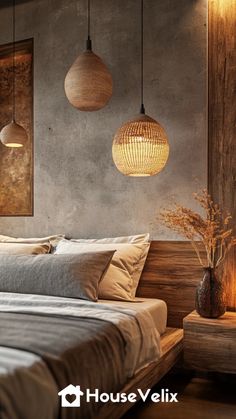 a bed sitting under two hanging lights in a bedroom next to a wooden headboard