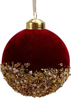 a red ornament with gold trim and beads on it's side, hanging from a string