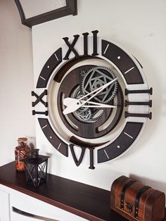 a large clock mounted to the side of a wall next to a chest of drawers