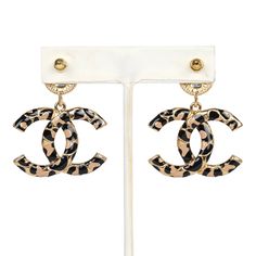 These Chanel large leopard print CC dangle earrings are in black and brown enamel with gold tone hardware, featuring CC enamel printed earrings dangling from black enamel button earrings with post back closures.Origin: FranceCondition: New and never wornAccompanied by: Chanel jewelry boxMeasurements: 1.6" height x 1" width Printed Earrings, Earrings Dangling, Black Earrings Dangle, Printed Jewelry, Chanel Jewelry, Button Earrings, Earrings Black, Gold Enamel, Black Enamel