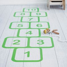 the floor is covered in green numbers and sandals on it's side, next to a wooden chair