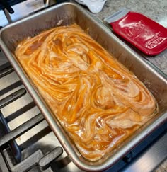 a metal pan filled with food sitting on top of a stove next to an oven