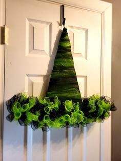 a green christmas tree hanging from the side of a door