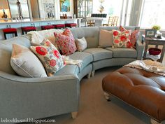 a living room filled with furniture and lots of pillows on top of it's couches