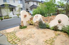 an outdoor garden area with stone walls and plants on the ground, along with brick walkways