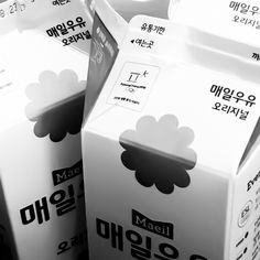 several milk cartons are stacked on top of each other in black and white colors