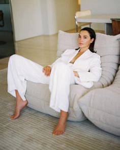 a woman sitting on top of a gray couch