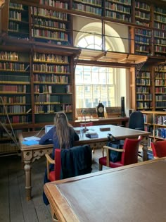 two people sitting at a table in a library