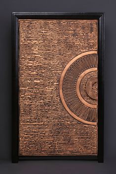 an intricately designed wooden plaque with black frame