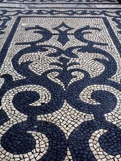 an intricately designed stone floor in the middle of a building with blue and white tiles