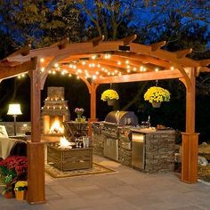 an outdoor kitchen and grill area lit up at night