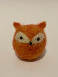 an orange stuffed animal with big eyes