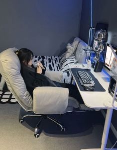 a woman sitting in a chair with her feet up on the desk while she is working