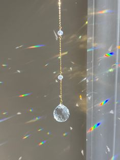 the sun shines brightly in front of a window with a long chain hanging from it