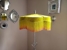 a table lamp with a yellow shade on it in the corner of a living room