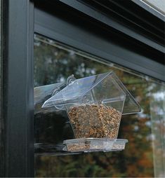 a bird feeder hanging from the side of a window