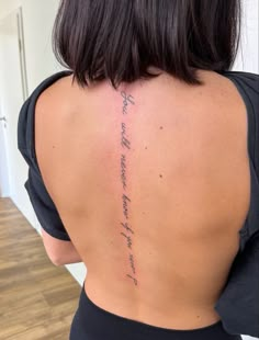 the back of a woman's body with writing on her upper back and lower back