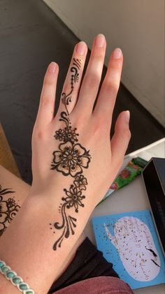 a woman's hand with henna tattoos on it