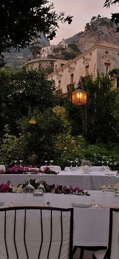 an outdoor dining area with tables and chairs set up for a formal function in the evening