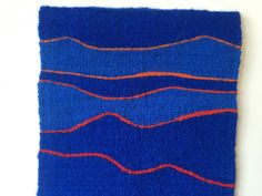 a piece of blue and orange knitted material with wavy lines on it's sides