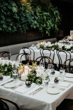 the tables are set with white flowers and place settings