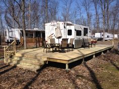 a deck with chairs and an rv parked in the background