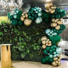 a green and gold balloon arch in the middle of a room