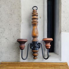 a wooden table with two candles on it and a window in the backround